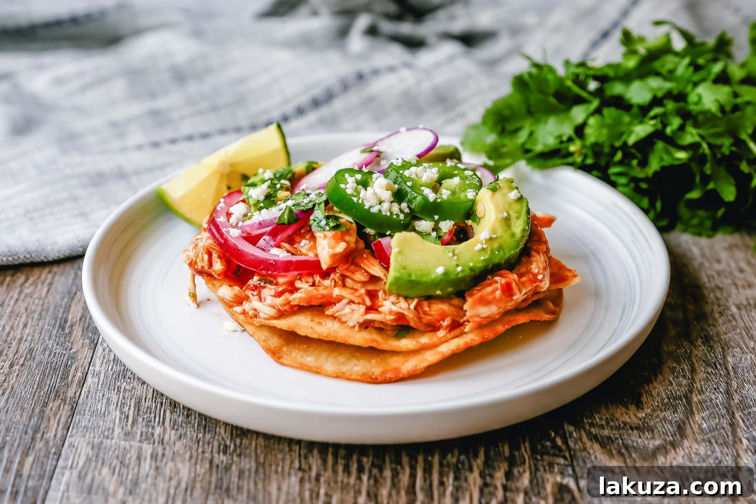 Fiesta Chicken Tostadas 2 Delicious Chile Chicken Tostadas with homemade crispy shells, seasoned chicken, cotija cheese, fresh avocado, cilantro, pickled red onion, and jalapeños