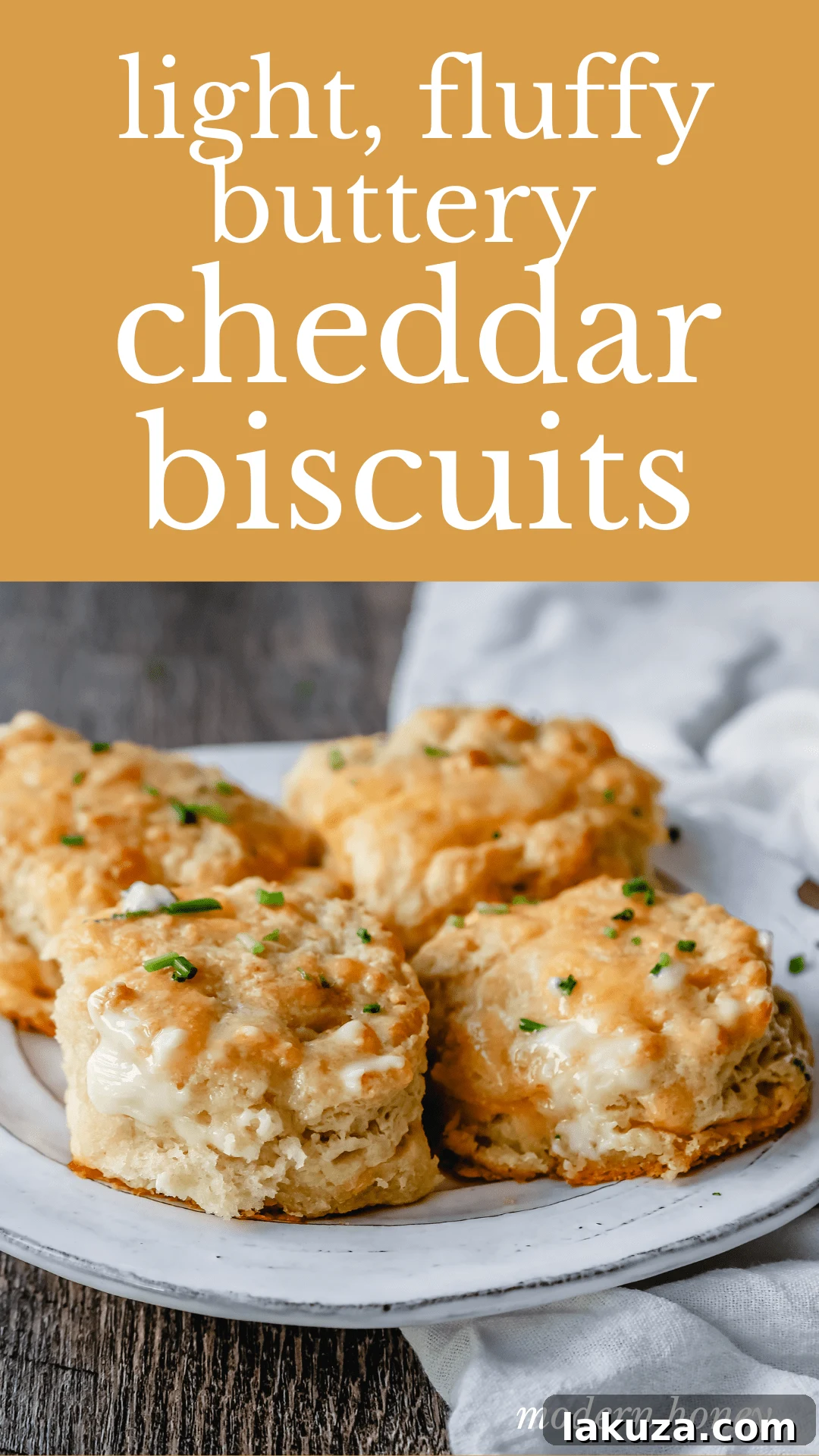 A basket full of golden brown cheesy garlic biscuits, still warm from the oven, ready to be served.