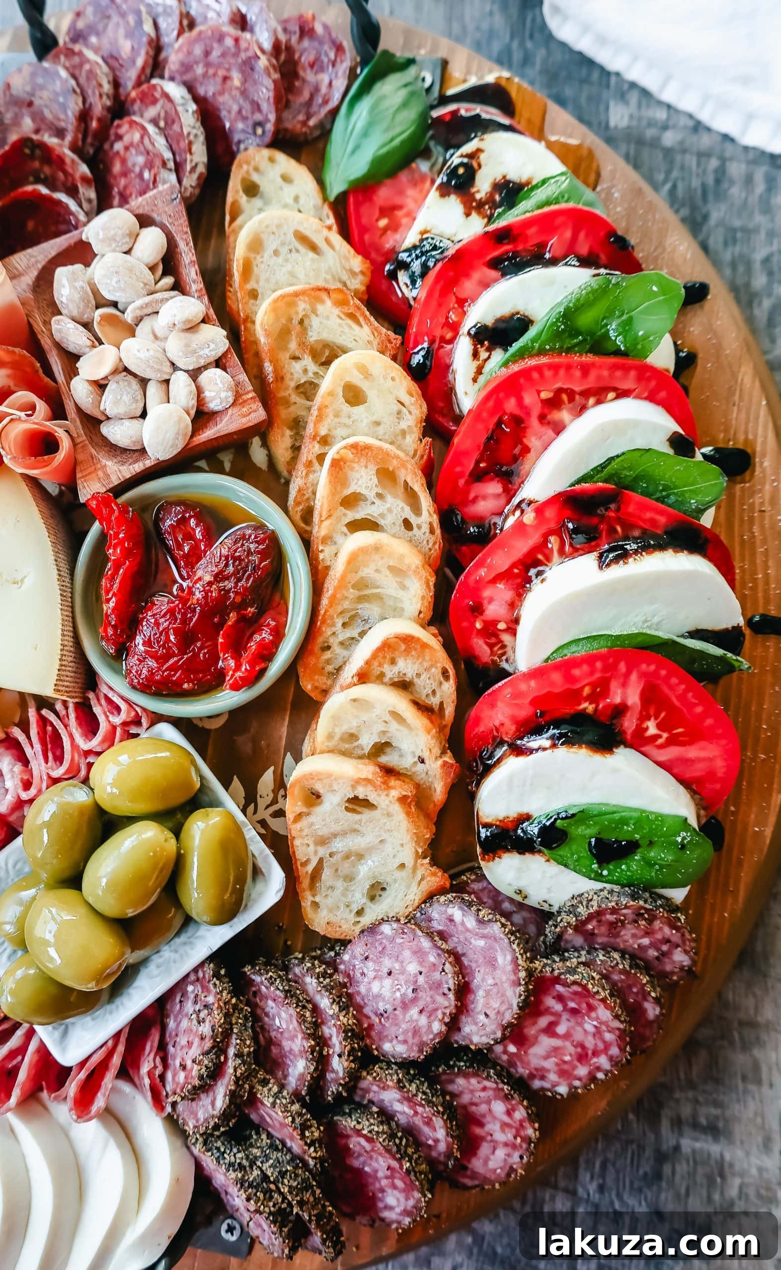 A generously portioned Italian Charcuterie board showcasing an array of cured meats, various Italian cheeses, fresh and dried fruits, nuts, and dipping sauces, beautifully presented for sharing.