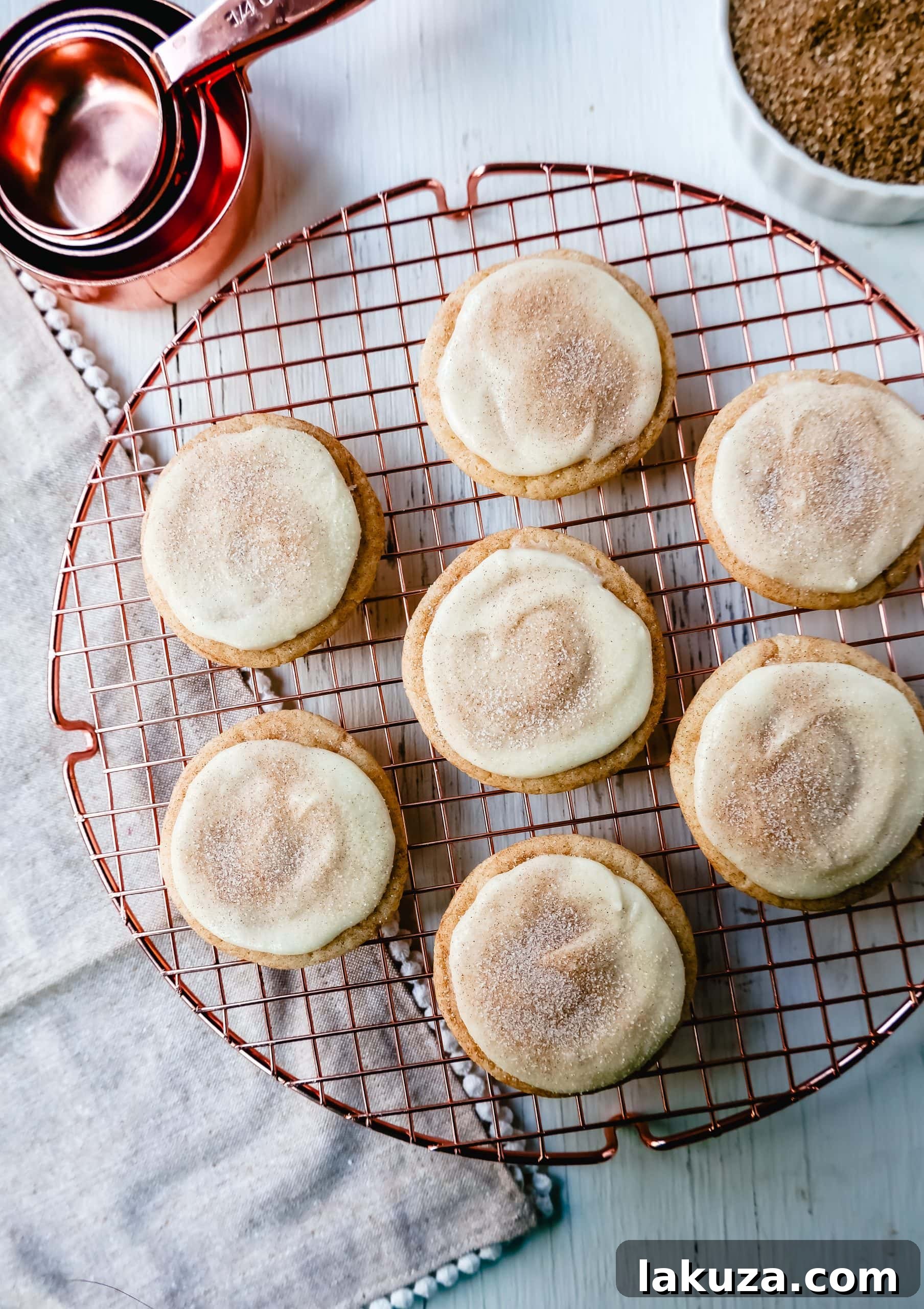 Close-up of a stack of Frosted Snickerdoodle Cookies, showcasing the soft texture and creamy frosting