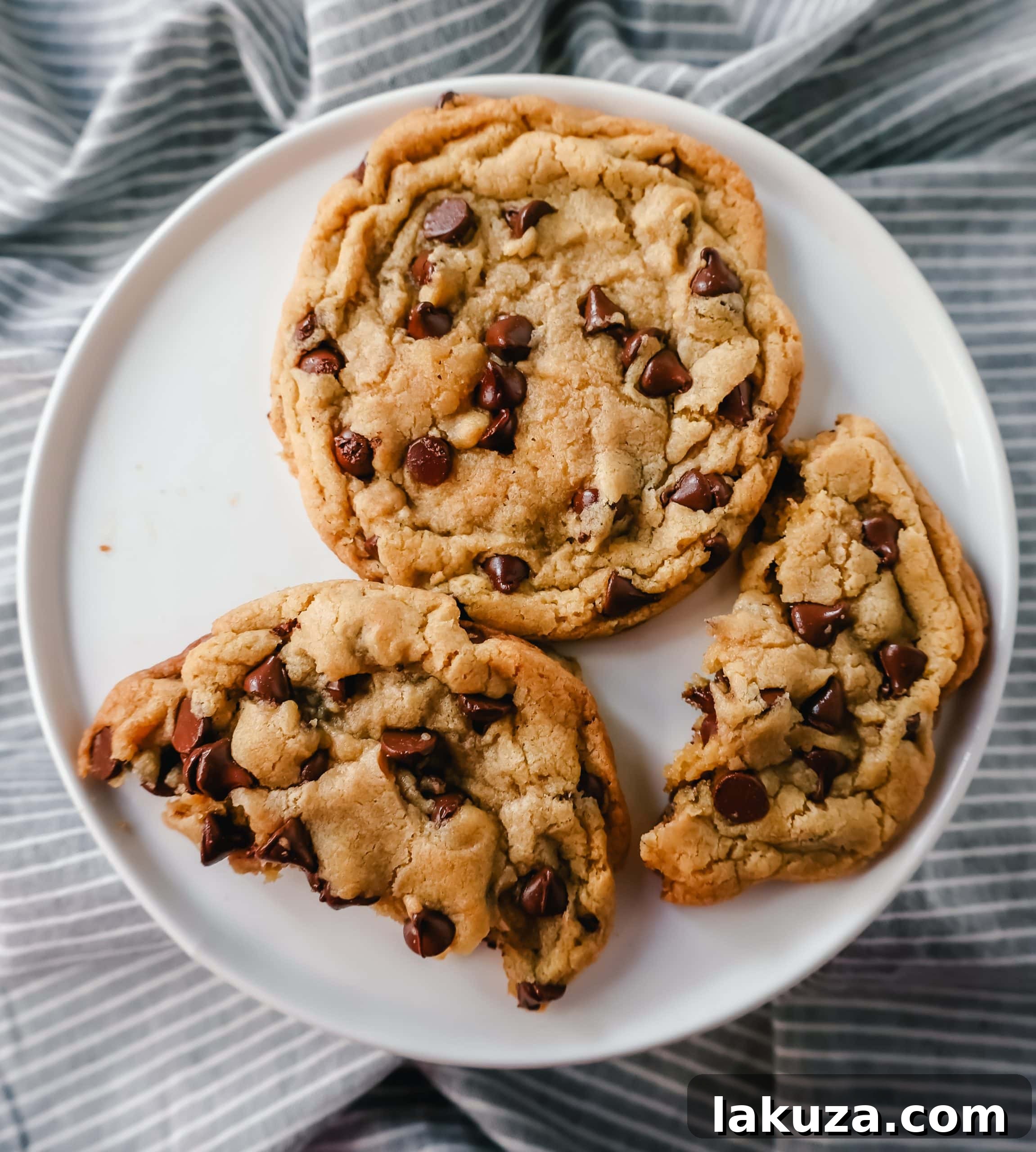 Sweetheart Chocolate Chip Cookies for Two 6 Three golden brown chocolate chip cookies cooling on parchment paper on a baking sheet.