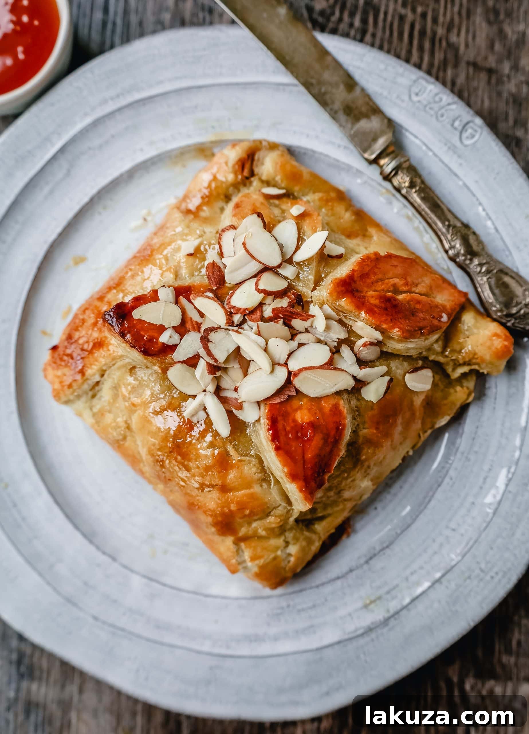 Deliciously baked Honey Almond Puff Pastry Wrapped Brie, ready to be served at your next party.