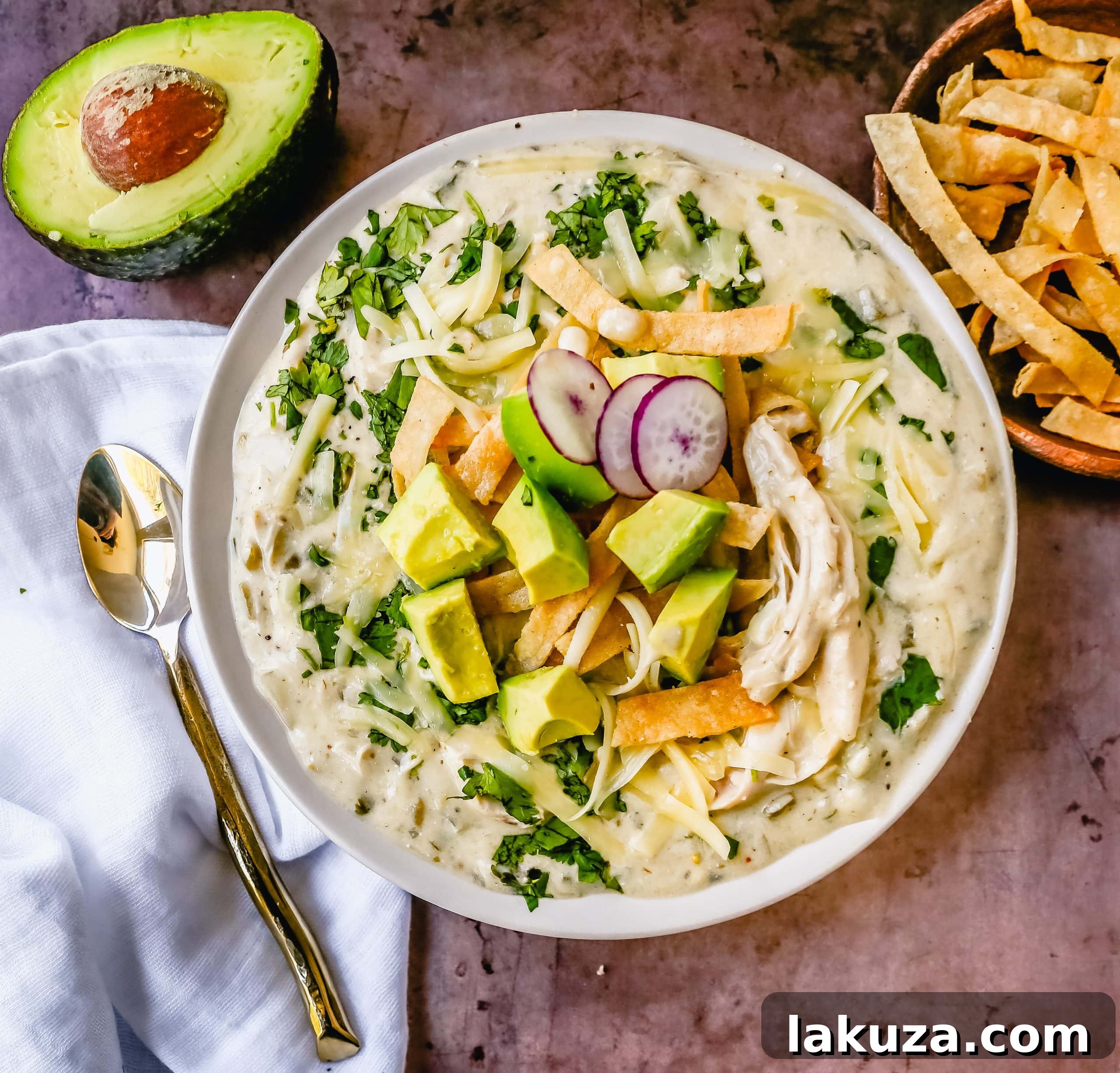 Hearty Southwestern Chicken Enchilada Soup 2 Creamy Green Chile Chicken Enchilada Soup topped with fresh avocado, cilantro, and crispy tortilla strips.