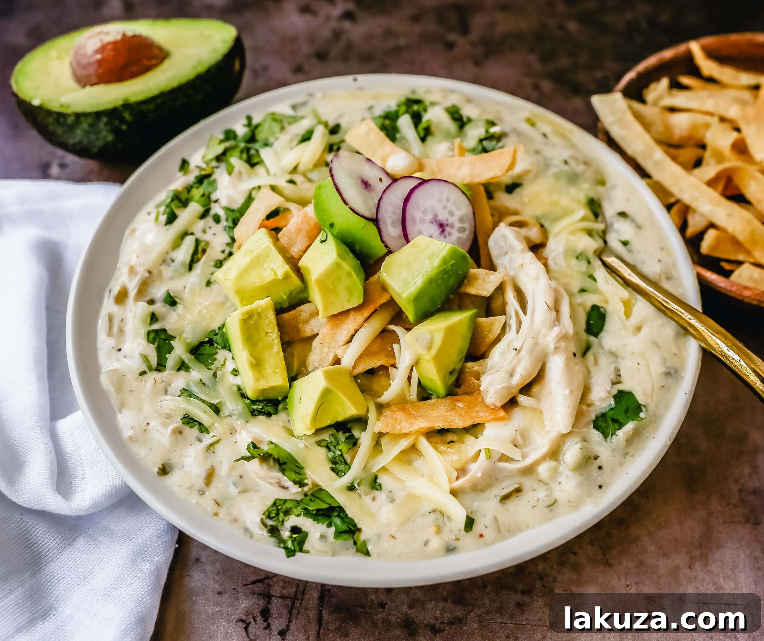 Hearty Southwestern Chicken Enchilada Soup 3 Delicious Green Chile Chicken Enchilada Soup in bowls with toppings.