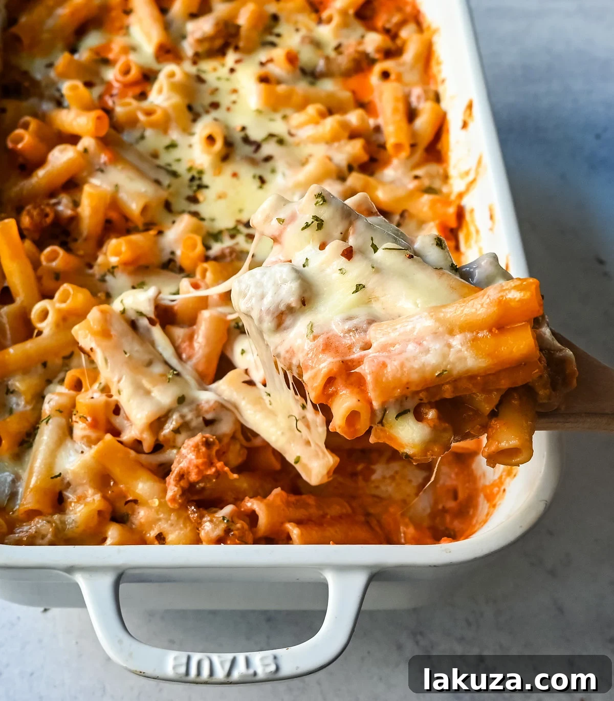 Close-up of a bubbling, cheesy baked ziti pasta dish with golden brown crust.
