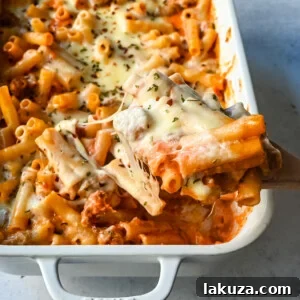 Baked Ziti Pasta with sausage, marinara, and melted cheese in a dish.