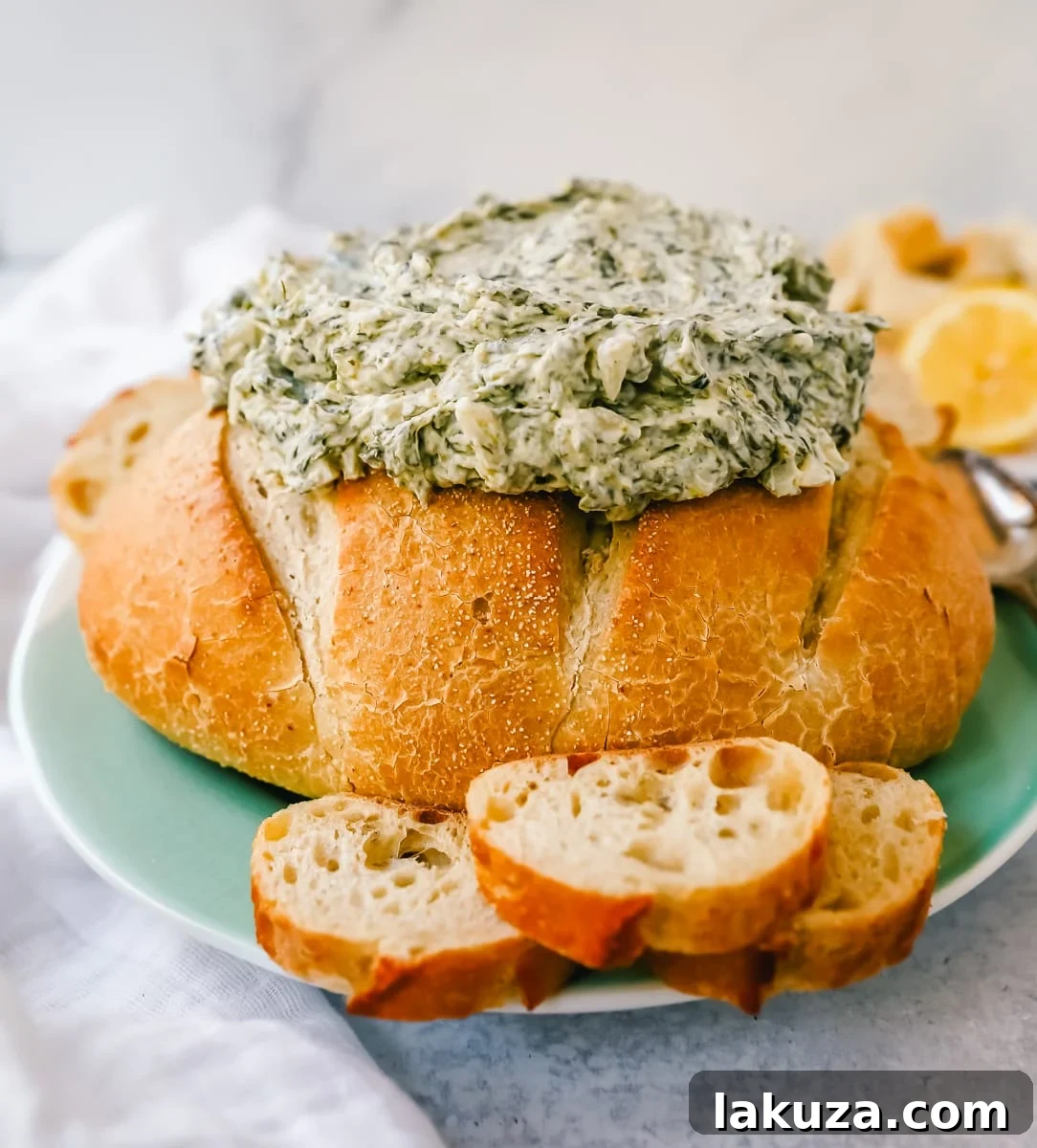 A beautifully set table with a large bowl of cold spinach dip, surrounded by a variety of vegetables like carrots, cucumbers, and bell peppers, and sliced bread, perfect for a party appetizer spread.