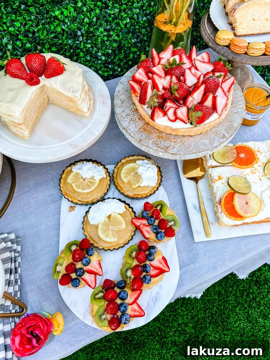 A tempting display of fruit tarts, lemon cream pie tarts, a strawberry tart, and a layered crepe cake, showcasing exquisite dessert options for a spring or Easter brunch.
