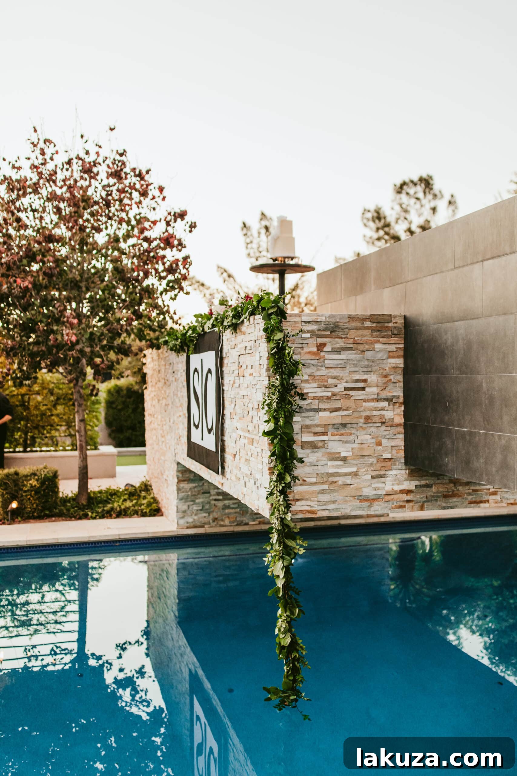 Outdoor wedding reception tables decorated with greenery garlands and candles