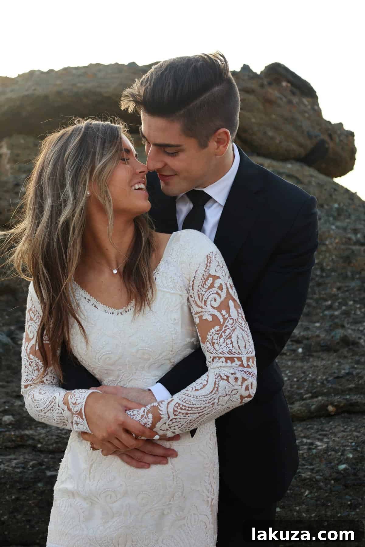 Groom Conner admiring his bride Sierra during their beach photoshoot