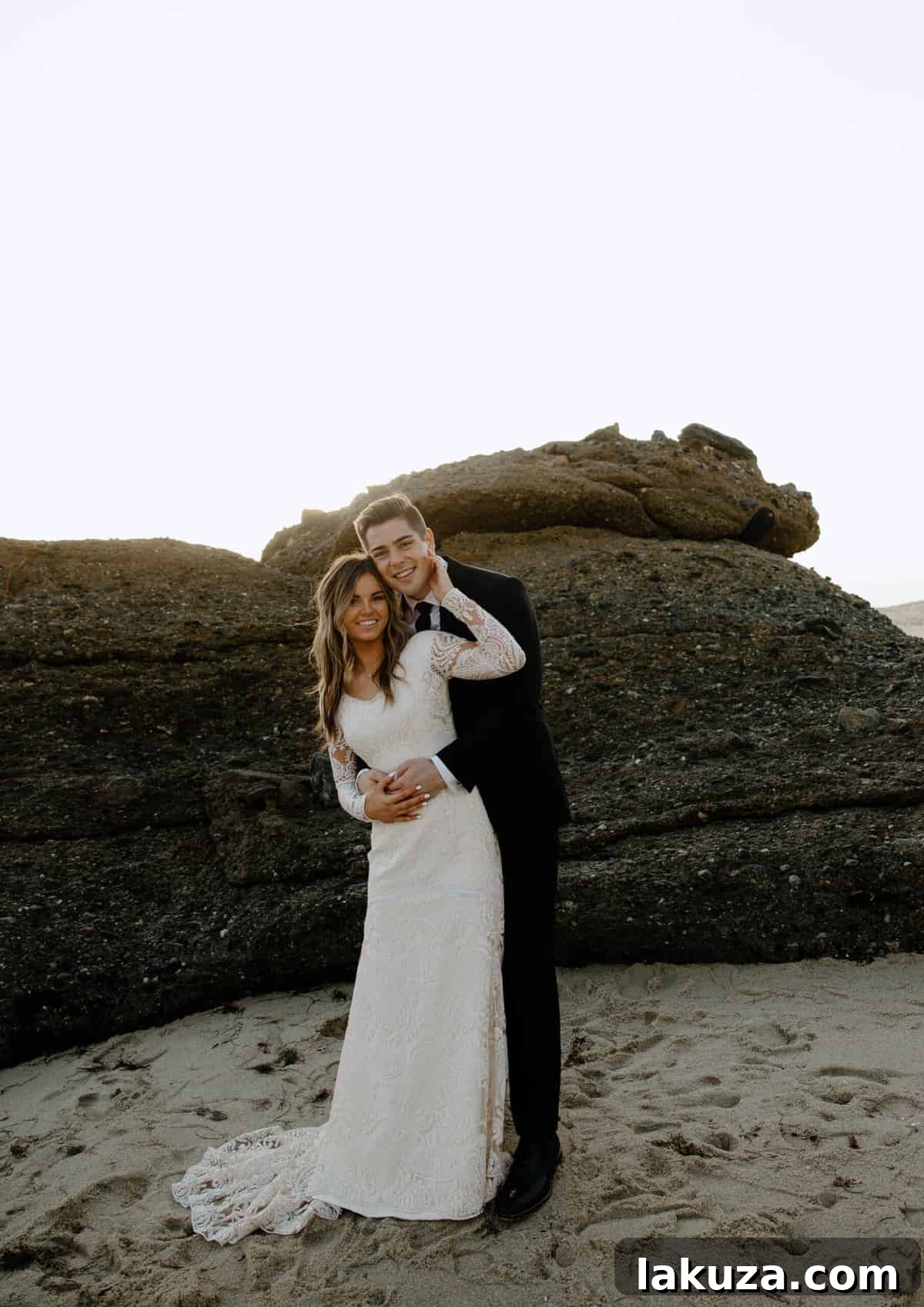 Sierra and Conner embracing on the beach