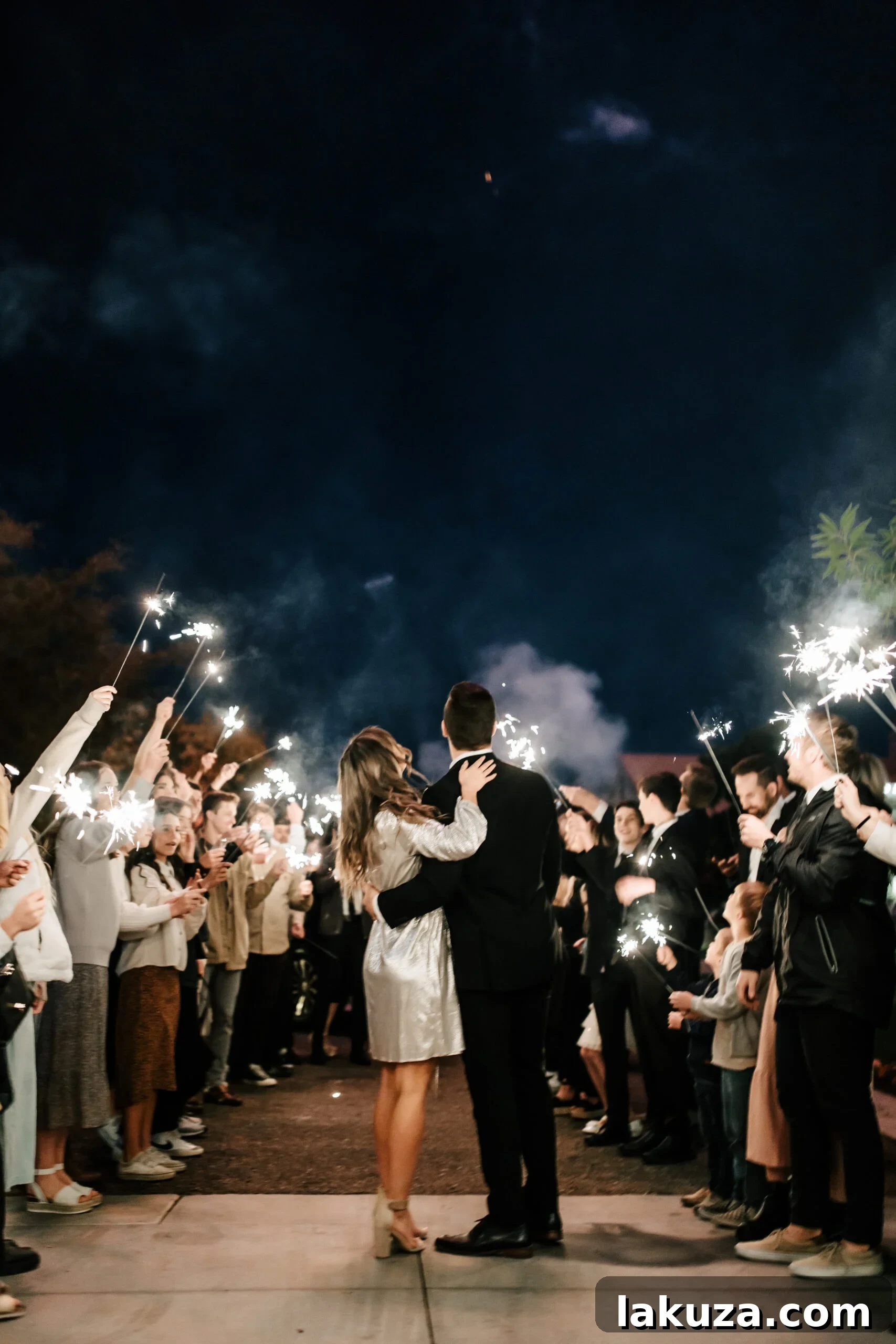 Bride and groom on the dance floor surrounded by friends