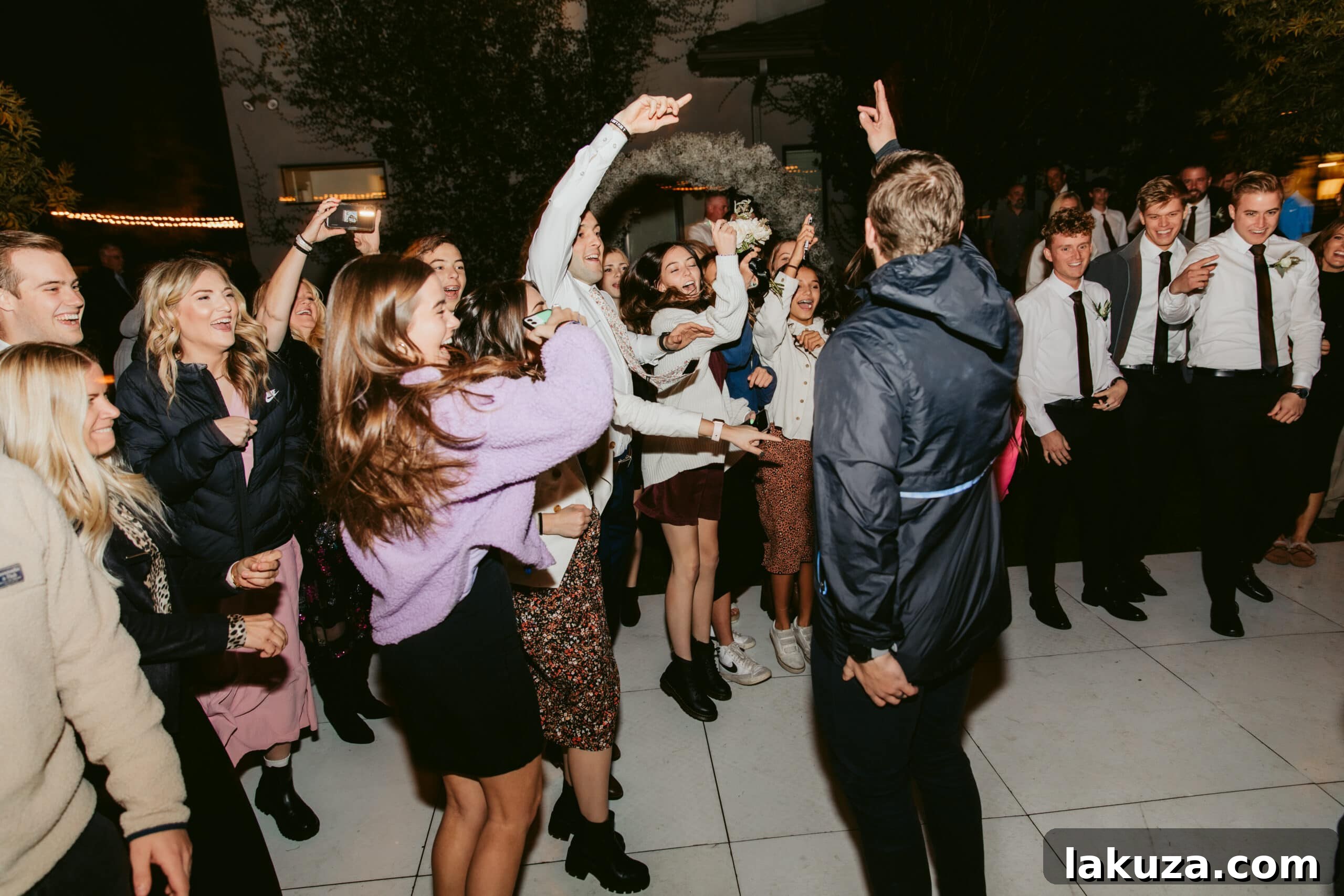Bride and groom dancing at their reception surrounded by loved ones