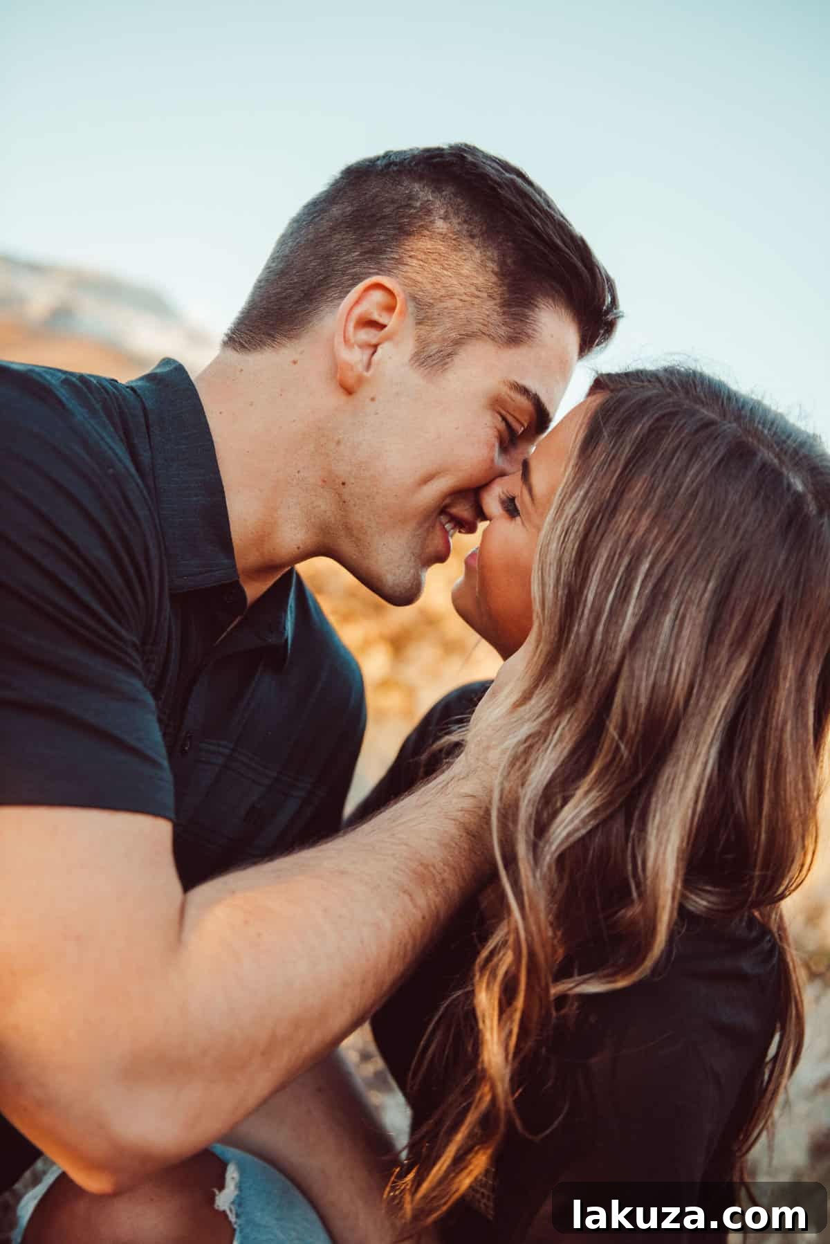Engaged couple walking hand-in-hand through a scenic park