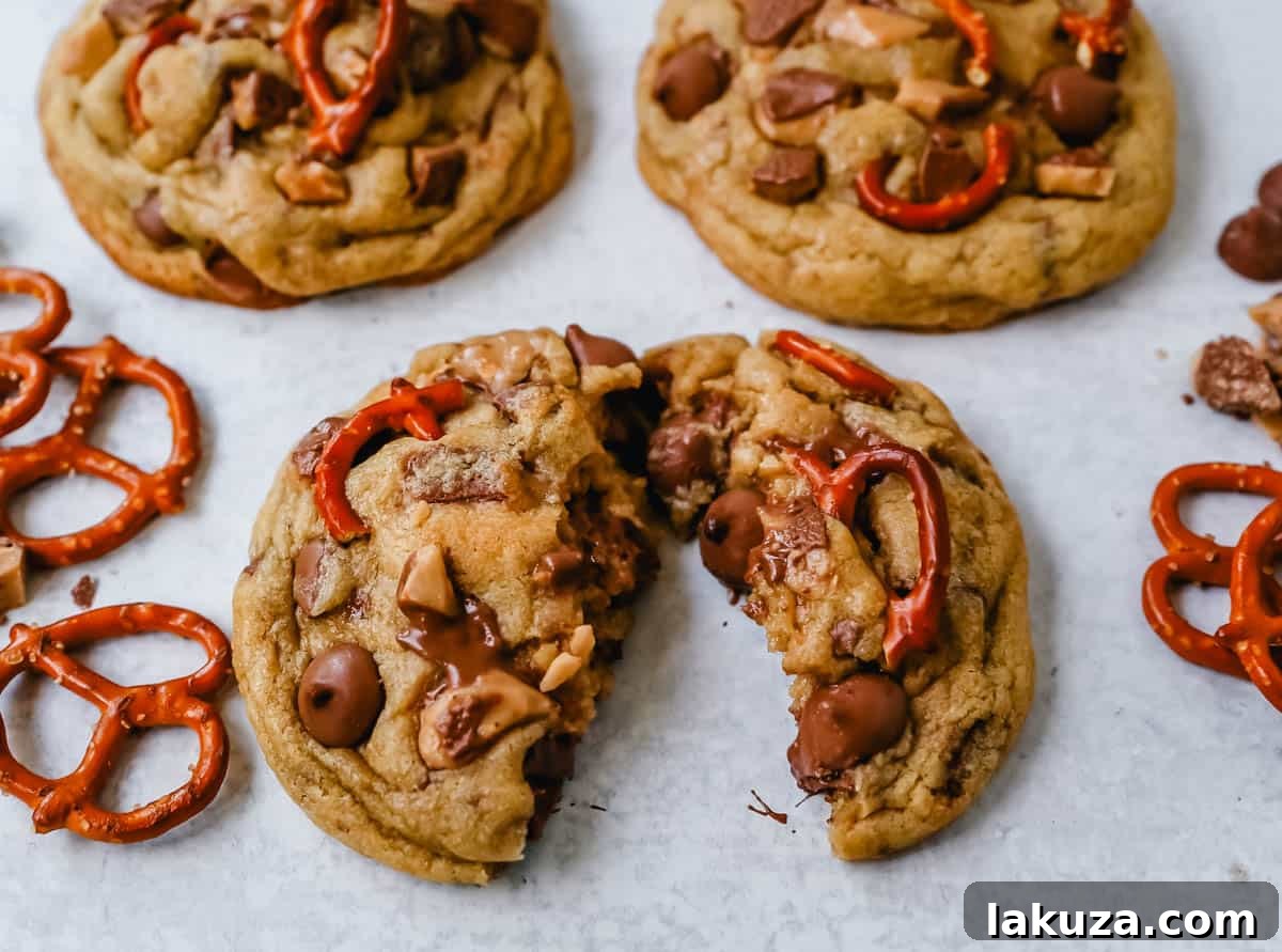 A thick and chewy chocolate toffee pretzel cookie split in half, showcasing its perfect blend of salty and sweet crunch.