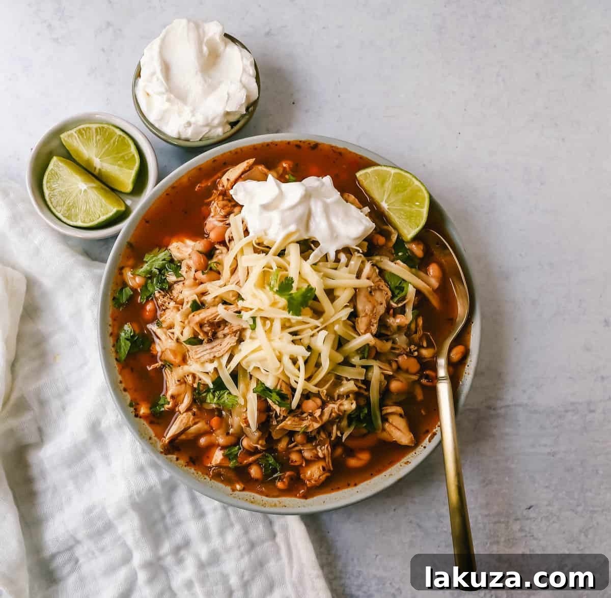 This quick and easy chicken chili is made in less than 30 minutes and filled with protein, good fats, and healthy carbs! This White Chicken Chili is a quick and easy soup recipe made with shredded chicken, onion, garlic, chili powder, green chilies, white beans, and ranch powder, and topped with cheese and sour cream.