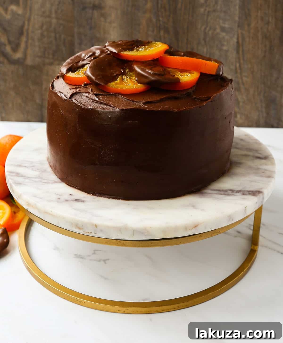 Assembled chocolate orange cake with a thick layer of creamy frosting between layers, ready for decoration.