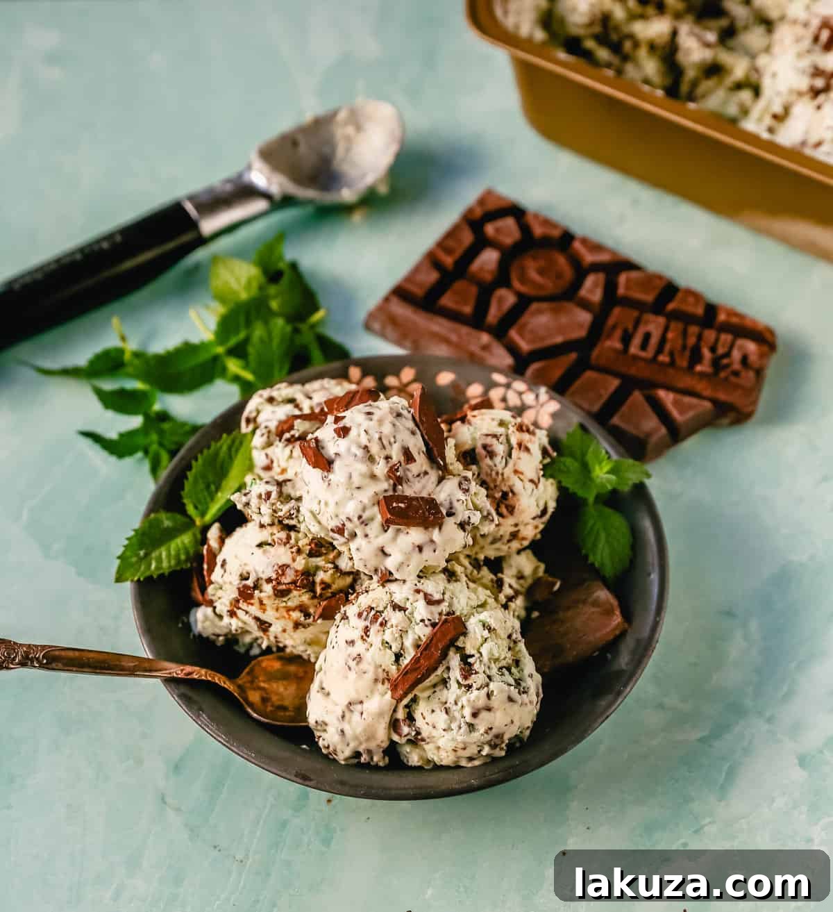 Emerald Mint Chocolate Dream 2 Lush scoop of homemade mint chocolate chip ice cream in a bowl, showcasing its creamy texture, vibrant green hue, and abundant chocolate chunks, perfect for a summer dessert.