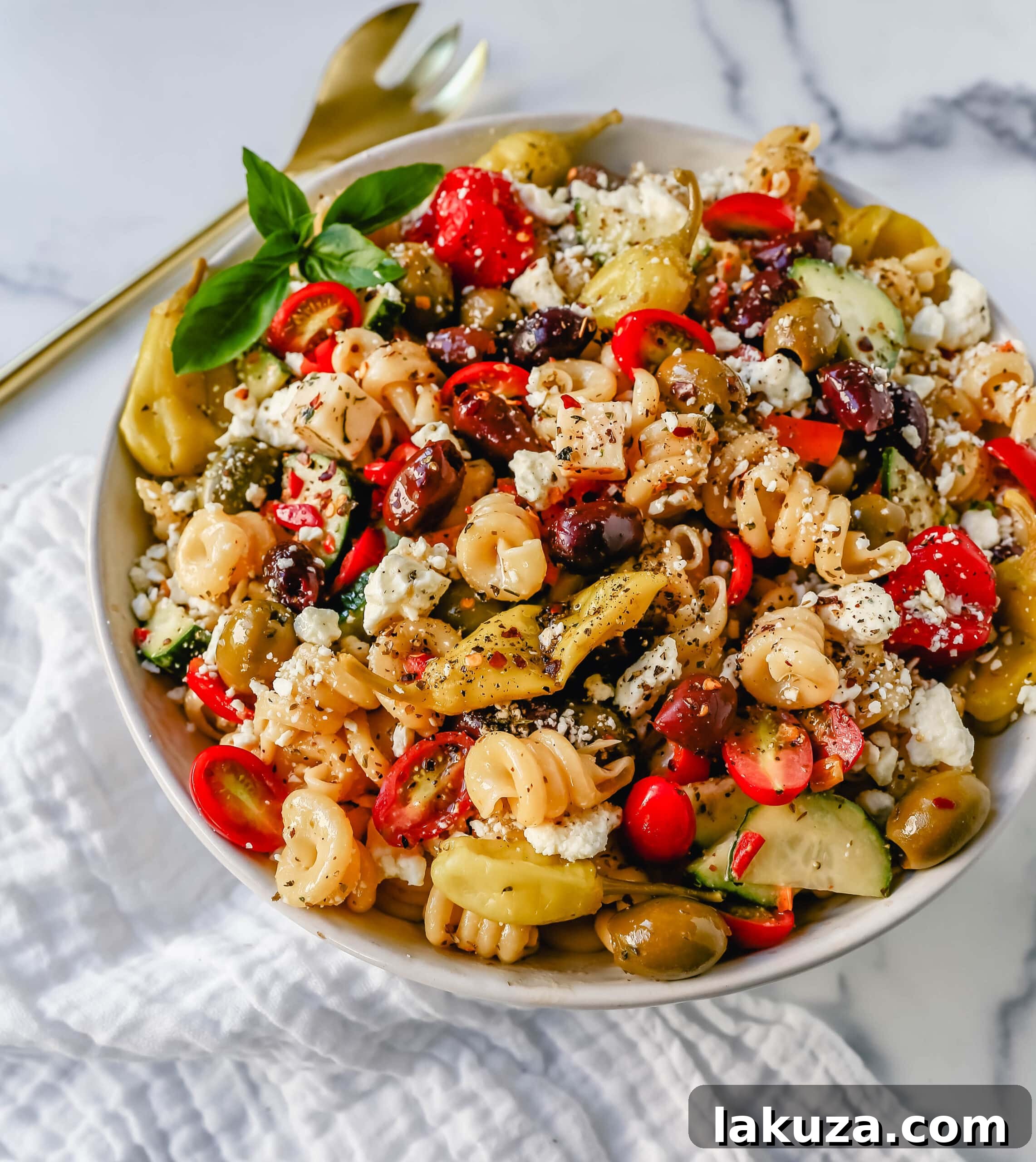 Freshly tossed Greek Pasta Salad with a rich homemade dressing, showcasing its appetizing appeal.