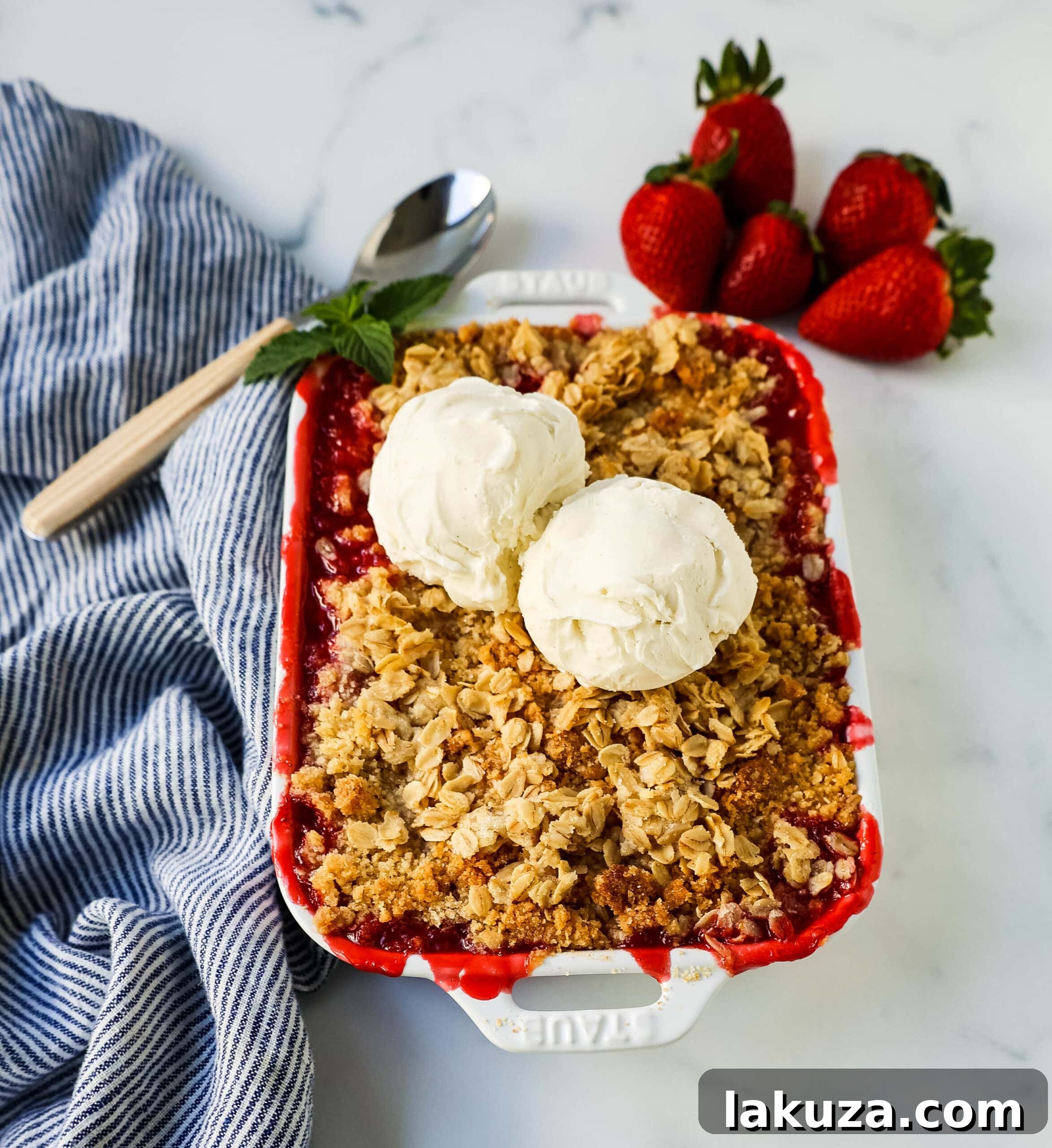 Close-up shot of the Strawberry Crisp in a baking dish, showing the bubbly strawberry filling and golden oat crumble topping.
