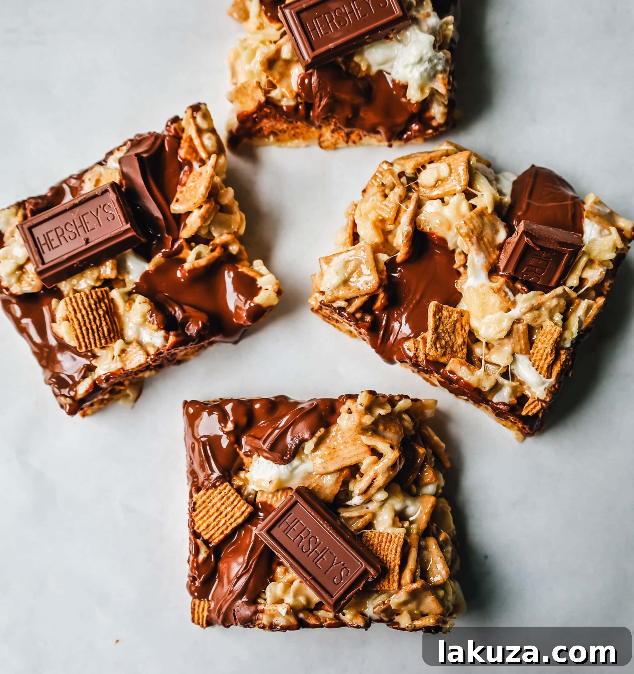 A hand reaching for a piece of S'more Rice Krispie Treat from a tray, highlighting its tempting gooey texture.