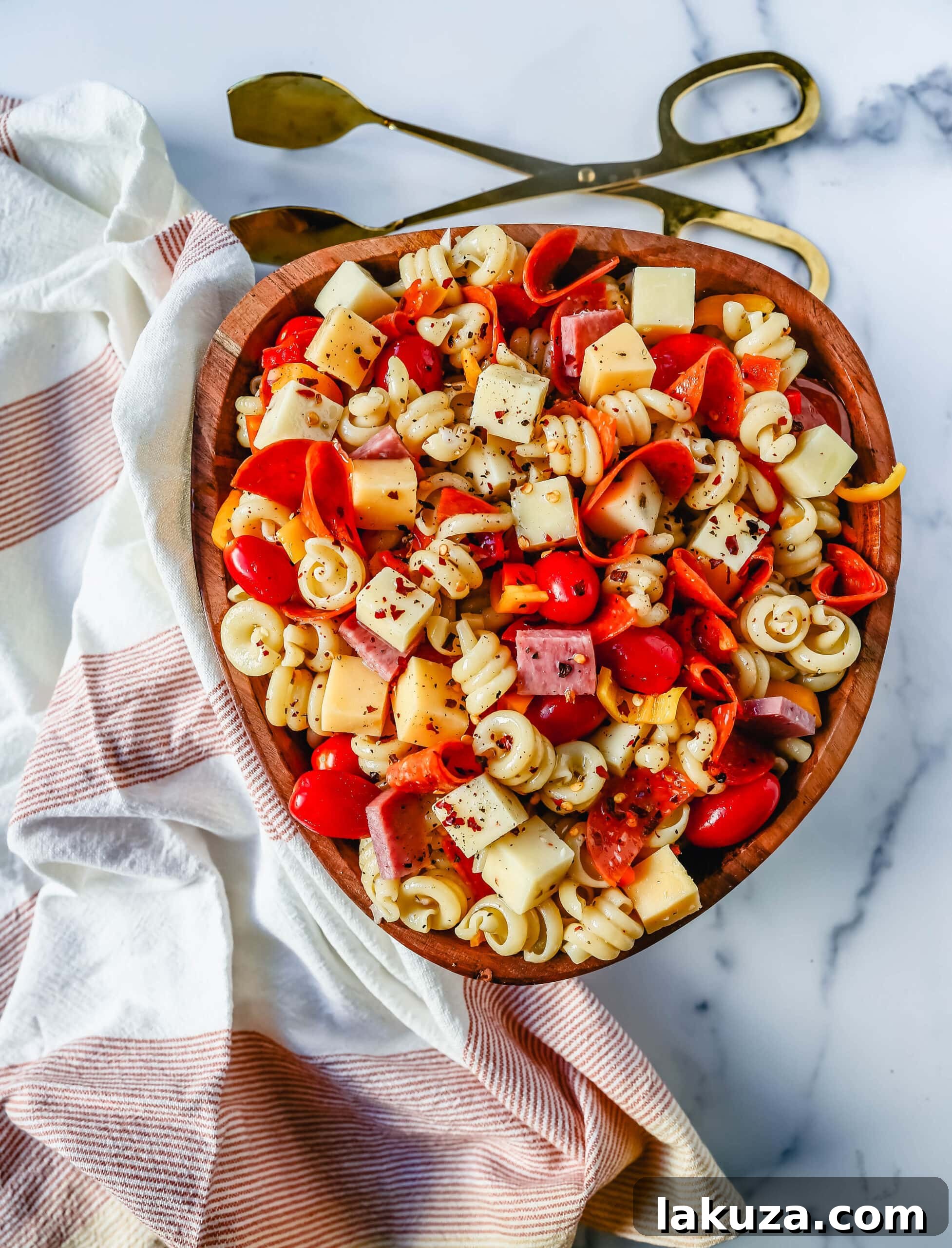 A close-up of fresh, colorful vegetables and ingredients for pasta salad