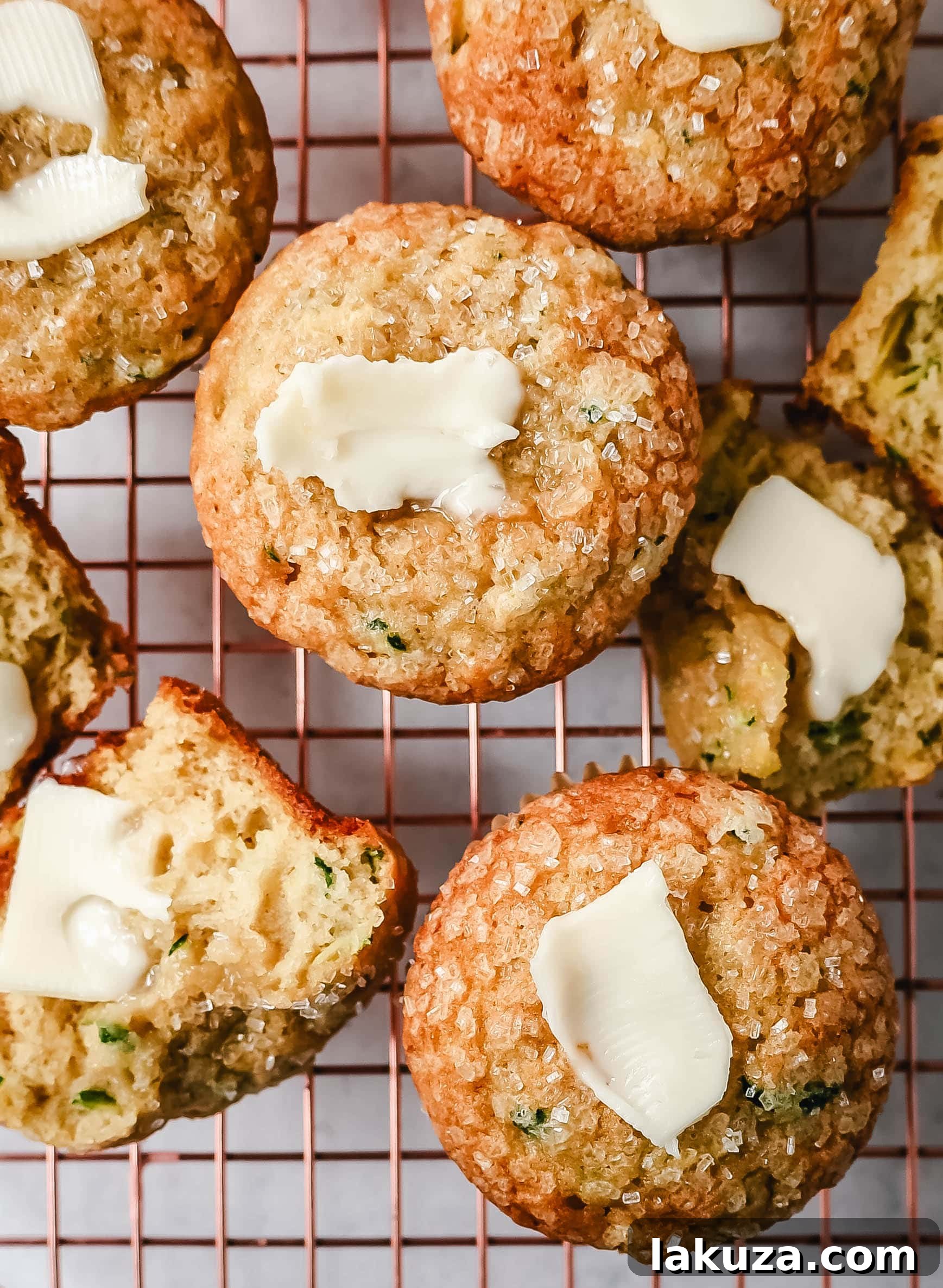 A close-up of a perfectly baked zucchini muffin, showcasing its golden-brown top and tender interior.