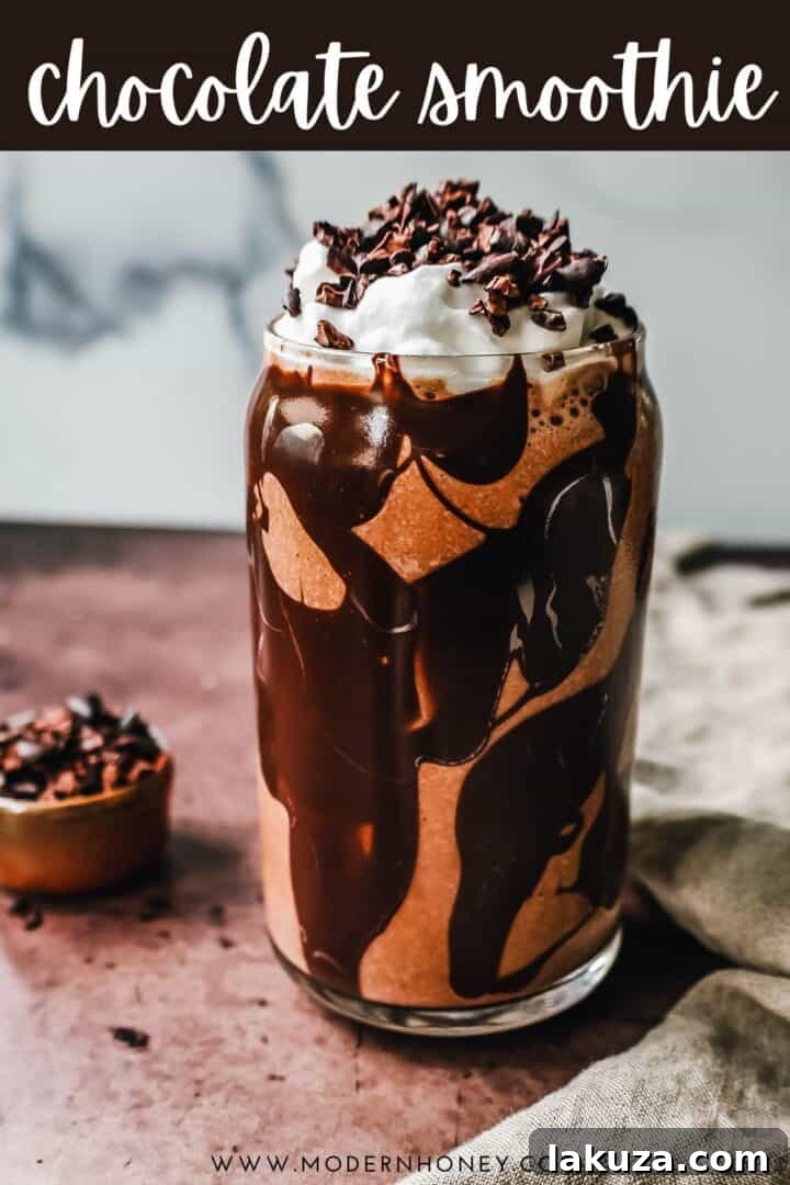 Final presentation of the Chocolate Almond Butter Smoothie in a glass with a spoon, highlighting its creamy texture.
