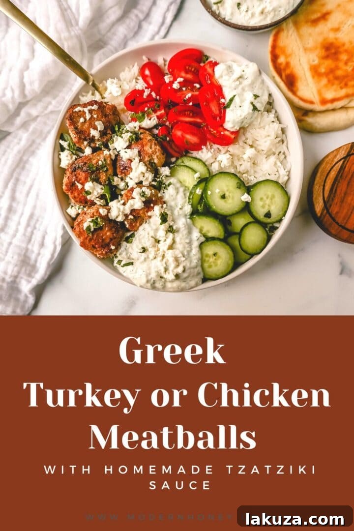 A vibrant Greek Chicken Meatball Bowl with homemade tzatziki, fresh vegetables, and rice.
