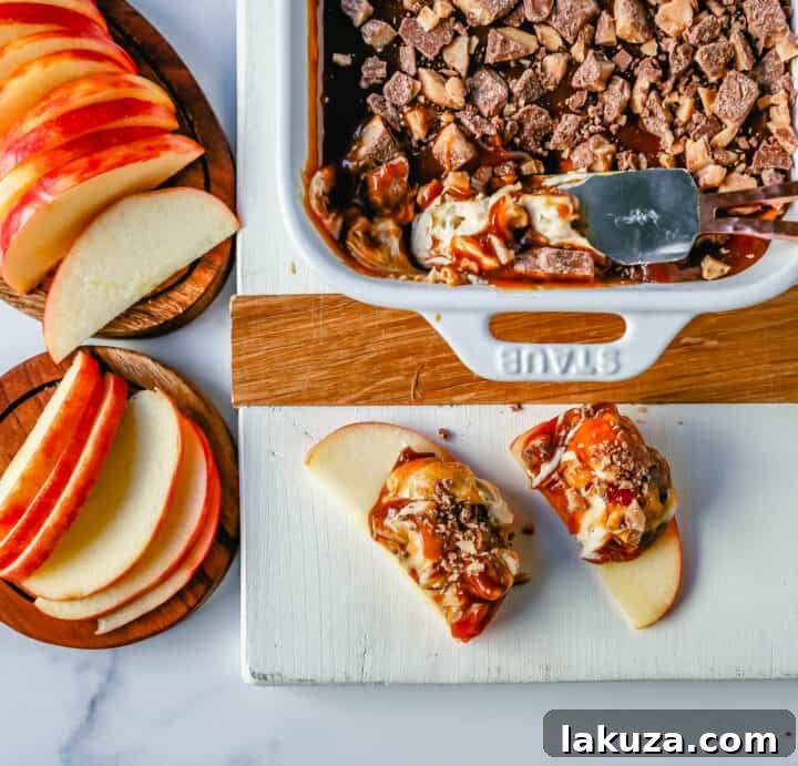 A rustic overhead shot of the Caramel Apple Toffee Dip, featuring a swirling caramel topping and crunchy toffee pieces. It's accompanied by neatly fanned apple slices, suggesting a cozy autumn treat.