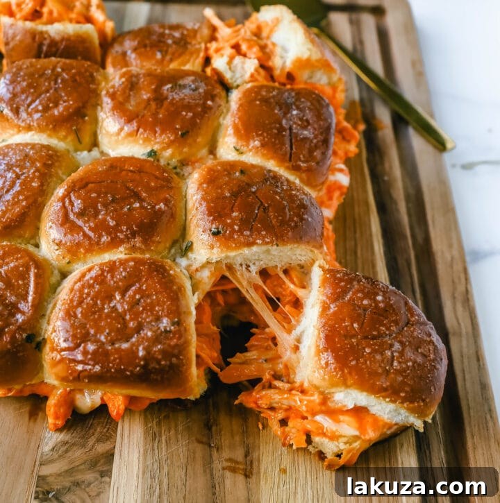 Close-up of baked Buffalo Chicken Sliders, showcasing the melted mozzarella and golden garlic butter buns.