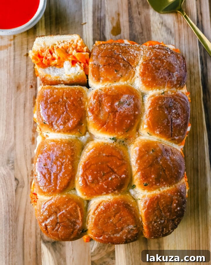 Ingredients for Buffalo Chicken Sliders laid out, including shredded chicken, sauces, cheese, and rolls.