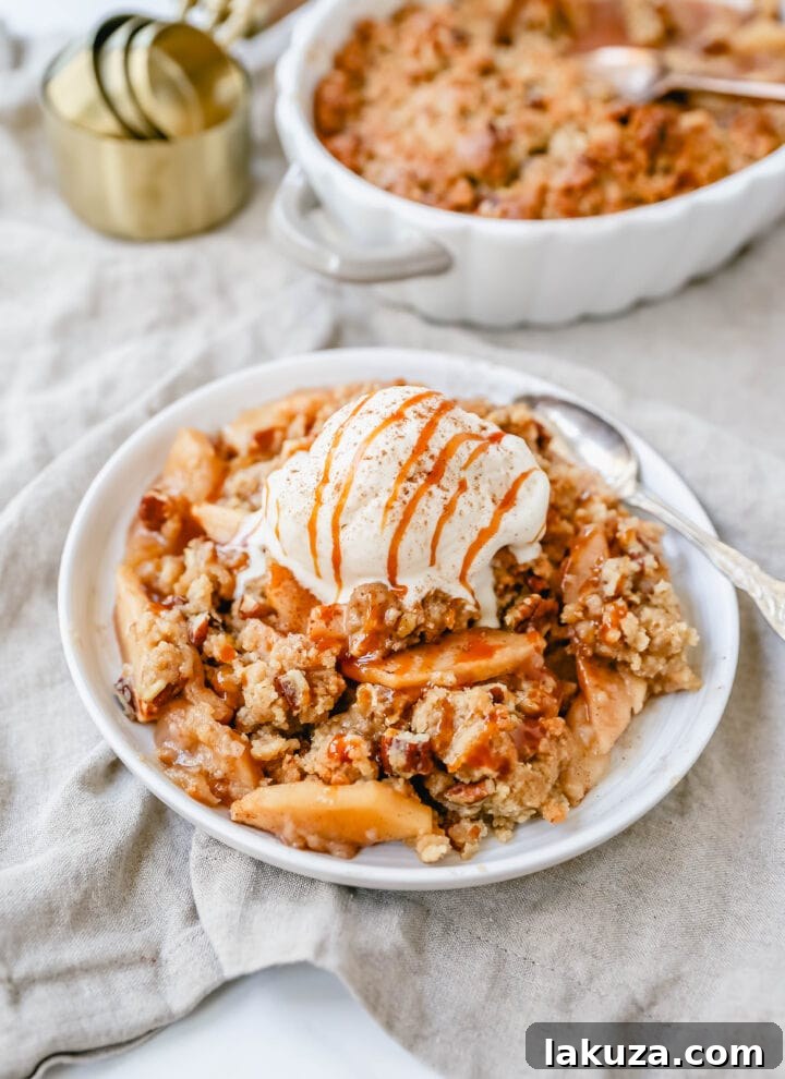 Simple Apple Crumble Bliss 2 Homemade Apple Crumble Recipe made with fresh apples tossed in cinnamon sugar and topped with a brown sugar crumble made with butter, pecans, brown sugar, and flour. This apple crumble is baked until bubbly and topped with vanilla ice cream. An easy apple dessert!