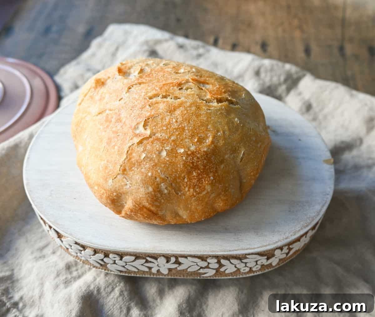 Effortless Overnight Artisan Loaf 6 A freshly baked No-Knead Dutch Oven Bread loaf on a cooling rack, steam gently rising, highlighting its perfect crust and shape. A testament to easy artisan baking.