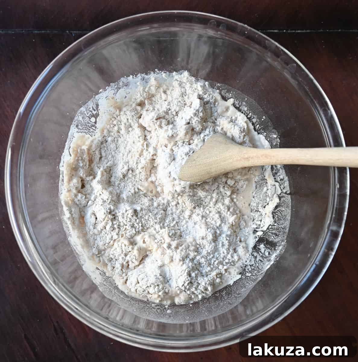 Effortless Overnight Artisan Loaf 10 Adding warm water to the dry ingredients for no-knead bread, initiating the dough formation.