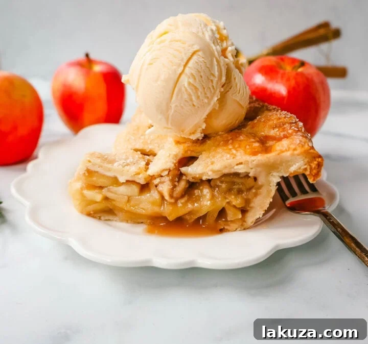A whole homemade apple pie cooling on a wire rack, with a beautiful crimped crust.
