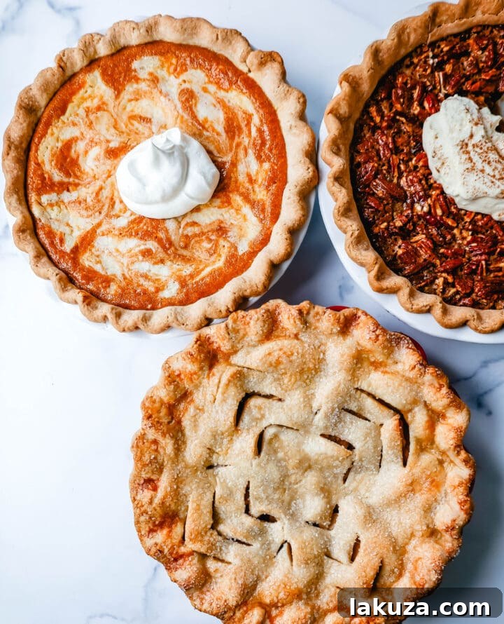 A festive Thanksgiving table laden with various pies, including apple, pumpkin, and pecan.