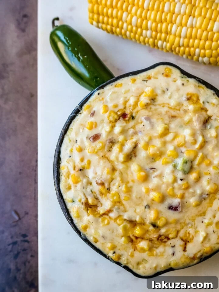 Rich and creamy Southwest Creamed Corn with vibrant green jalapenos and red onions, ready to serve.