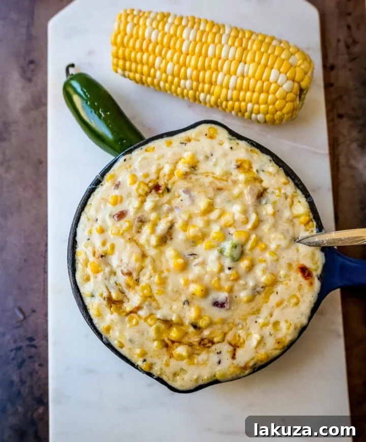 Close-up of creamy Southwest corn with melted pepper jack cheese, peppers, and onions.