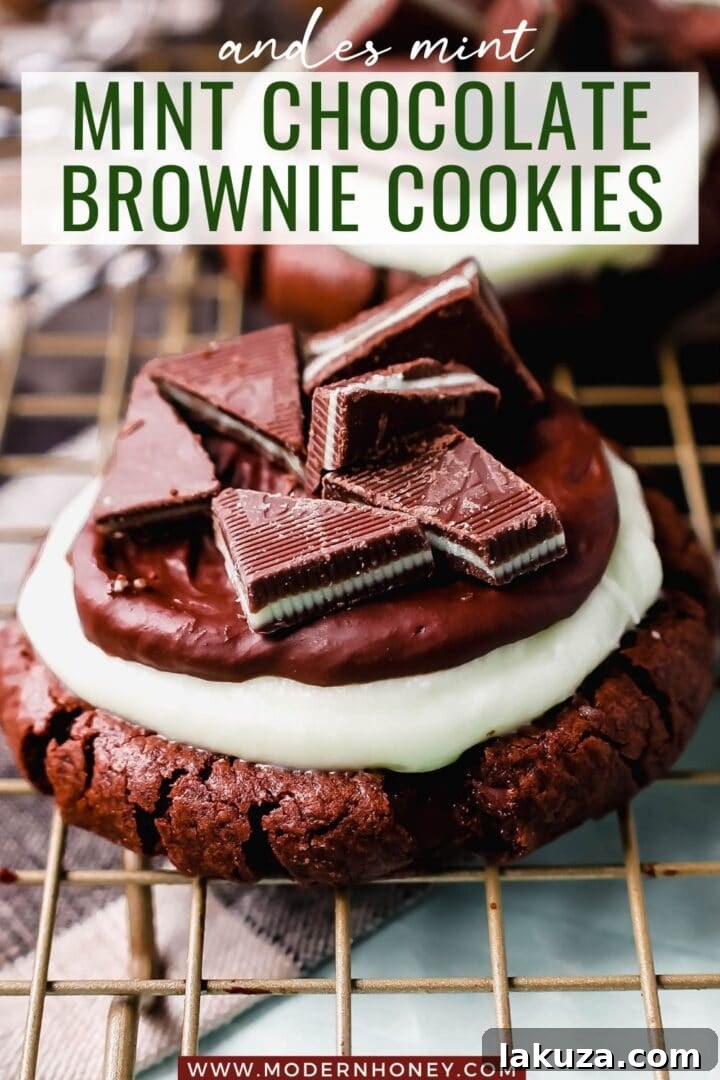 A stunning vertical shot of Frosted Mint Chocolate Brownie Cookies, layered with rich cookie, mint frosting, and glossy ganache, topped with chopped Andes mints. A festive and decadent dessert.