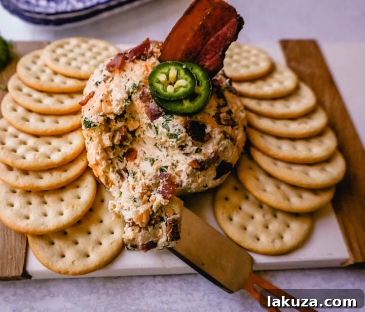 Close-up of a Cheddar Bacon Jalapeño Cheese Ball, garnished with fresh cilantro and surrounded by crispy bacon bits, ready to be served.
