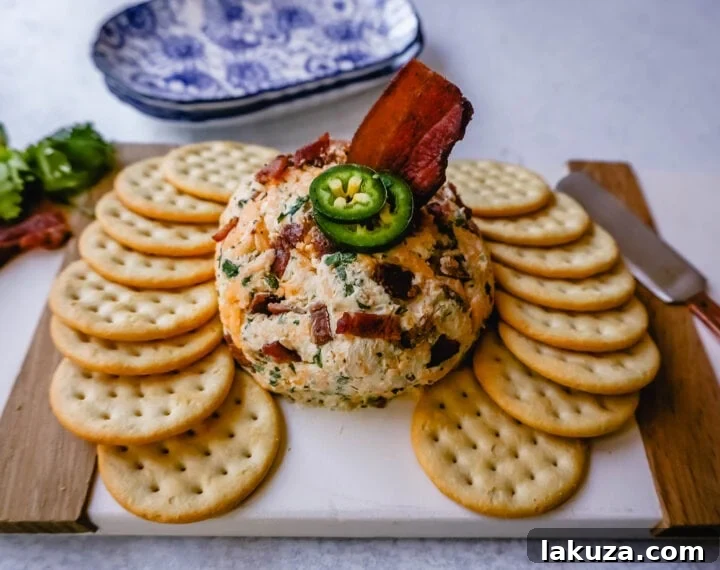 A beautifully textured Cheddar Bacon Jalapeño Cheese Ball, artfully arranged on a serving board with a variety of crackers and fresh herbs.