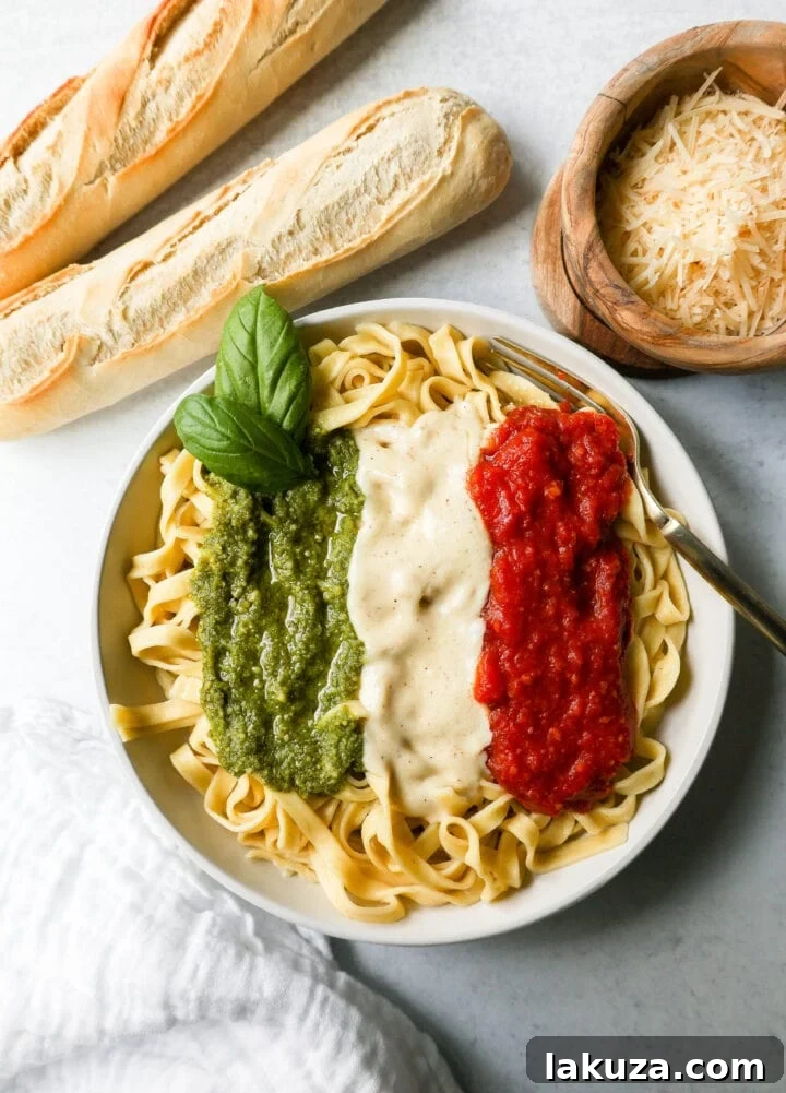 Christmas Pasta on a serving platter, showing the distinct layers of Alfredo, Marinara, and Pesto sauces.