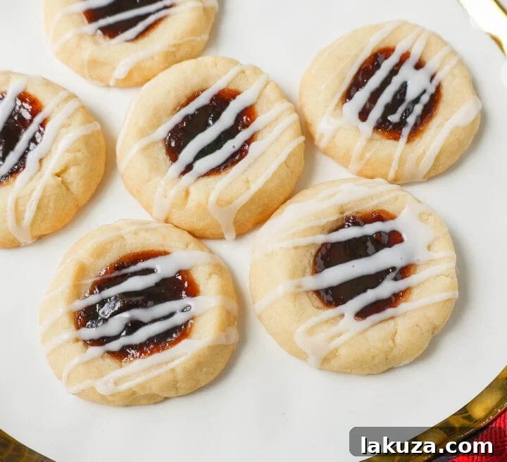 80 Irresistible Christmas Cookie Recipes 29 Raspberry Almond Jam Thumbprint Cookies: buttery shortbread with jam and vanilla/almond glaze. A festive and delicious Christmas cookie!