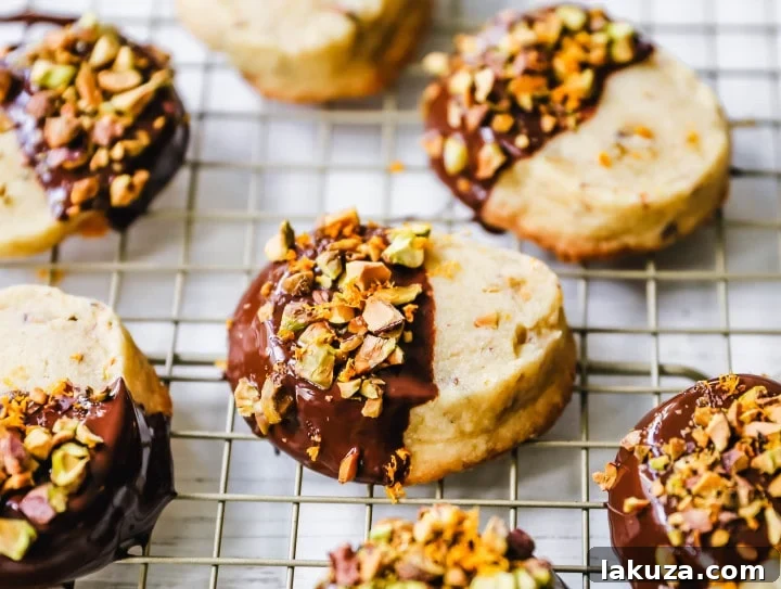 80 Irresistible Christmas Cookie Recipes 50 Chocolate-Dipped Pistachio Shortbread Cookies: rich, buttery shortbread with crunchy pistachios, dipped in chocolate, and sprinkled with orange zest and more pistachios. A beautiful and festive Christmas cookie!