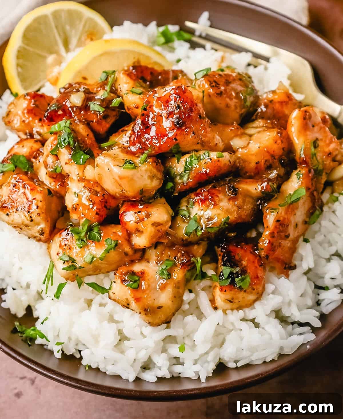 Pan-seared tender Honey Lemon Chicken pieces garnished with fresh herbs, ready to serve.