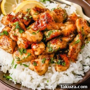 Delicious Honey Chicken with a sticky glaze, garnished with fresh herbs.