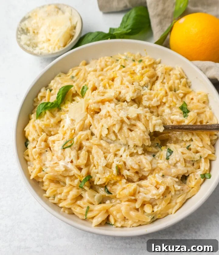 Velvety Lemon Orzo 3 Close-up of creamy lemon orzo pasta, garnished with fresh basil, showcasing its rich texture.