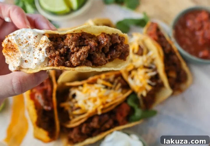 Savory Ground Beef Tacos 5 A plate of freshly prepared ground beef tacos with a side of chips and salsa.