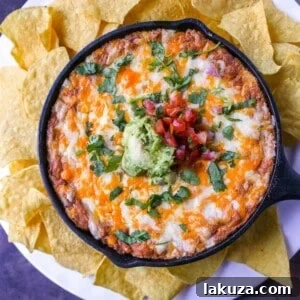 This is the best bean dip recipe ever! This is such an easy bean and cheese dip made with creamy beans, sour cream, cream cheese, taco seasoning, hot sauce, and lots of Mexican cheese! This easy bean dip is the best appetizer recipe. 